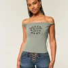 Camiseta gráfica con hombros descubiertos y estampado de Nueva York