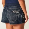 Mini shorts vaqueros de talle ultra bajo, lavado oscuro y bordado de mariposa