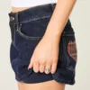 Minifalda pantalón vaquera de talle bajo, lavado oscuro y bolsillos a cuadros
