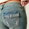Vaqueros bootcut de talle bajo con bordado de mariposas y lavado medio