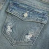 Vaqueros bootcut de talle bajo con bordado de mariposas y lavado medio