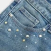 Vaqueros bootcut de talle bajo y lavado medio con tachuelas